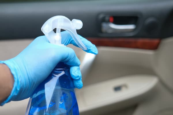 cleaning bottle with gloves on
