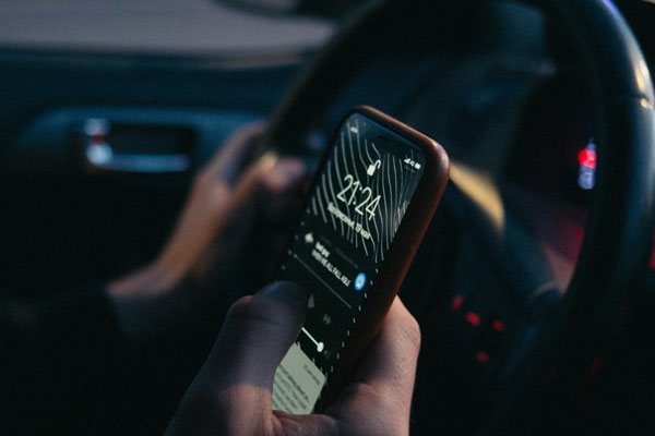 person on the phone while sat in the driver seat.
